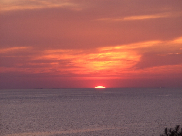 De zon zakt in de zee.