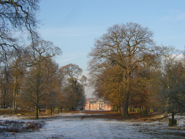 Het front van Dunham Massey door de bomen