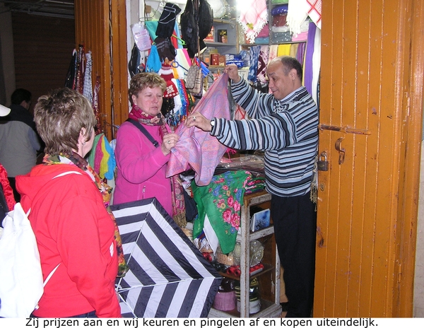 Een verkoper prijst zijn waar aan-sjaals