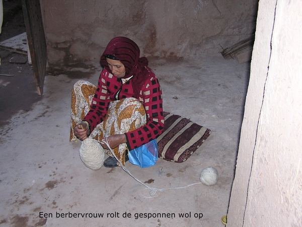 Een vrouw die wol oprolt in haar huisje