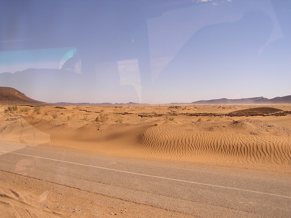 Woestijnzand naast/op de weg.