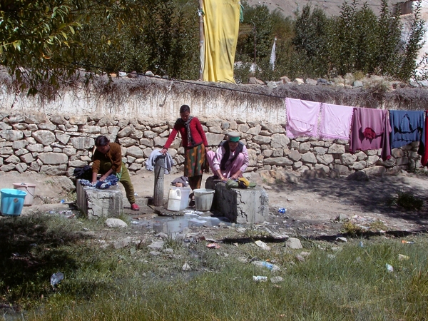 IN TABO VROUWEN DOEN DE WAS AAN DE WATERTAP