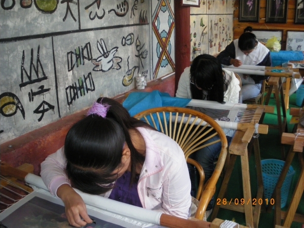 Lijiang-Bezoek Bai-volk, een zijdeatelier