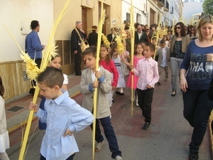 Kinderen met versierde witte palmtakken