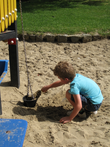 39) Ruben vult het emmertje met zand