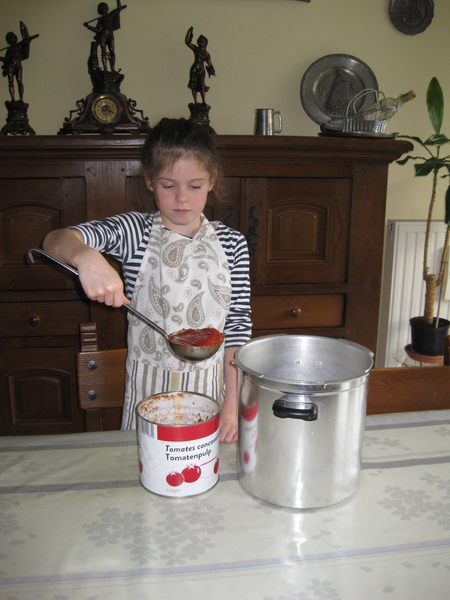 56) Jana schept tomatenpulp in de snelkookpan