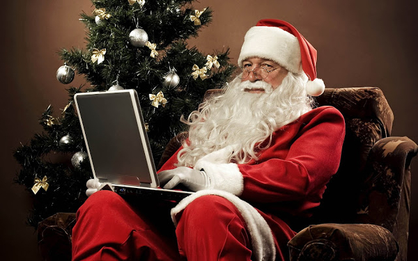 de-kerstman-met-een-laptop-op-schoot-hd-kerst-achtergrond