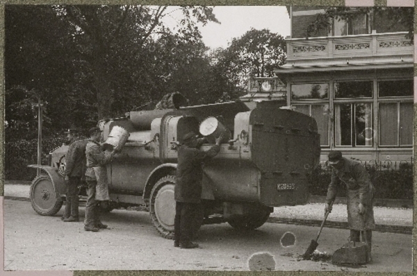 Vuilnismannen aan het werk met een huisvuilauto zoals dat ging om