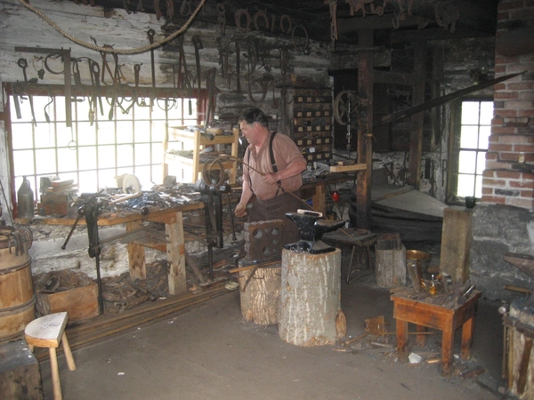 De blacksmith in zijn smederij