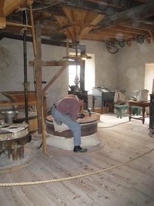 De molenaar maakt zijn molensteen grof.