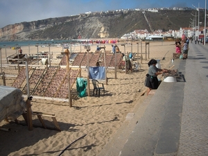 3f Nazare  _zicht op het strand met verkoopster in traditionele k