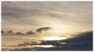 Zon zakt bij valavond achter de wolken. Kattendijkdok Oostkaai