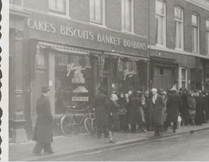 1942 Lange rij wachtenden voor banketbakkerswinkel Jamin op de Ho