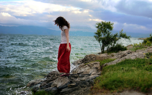 foto-van-een-vrouw-in-rode-rok-op-de-rotsen-bij-de-zee-hd-vrouwen