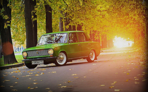 leuke-auto-achtergrond-met-een-groene-lada-en-bomen-met-herfstbla