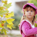 foto-van-een-kind-met-roze-kleding-in-de-herfst-met-herfstbladere