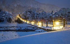 foto-van-een-besneeuwde-brug-met-lichten-aan-hd-winter-achtergron