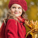 foto-van-een-meisje-in-het-rood-gekleed-met-herfstbladeren-in-haa