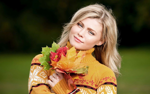 vrouw-met-gekleurde-herfstbladeren-in-haar-hand-hd-herfst-wallpap