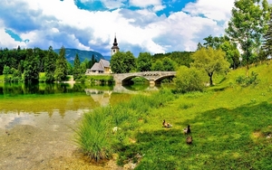 Slovenia-bridge-river-church-grass-summer-clouds_1680x1050