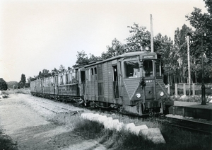 De M 67 met vier glanzende rijtuigen halteert te station Rhoon.
